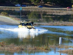 car driving through deep water on road at China Camp